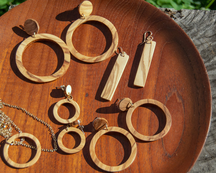 olive wood hoops, dangles, and necklace on wood plate
