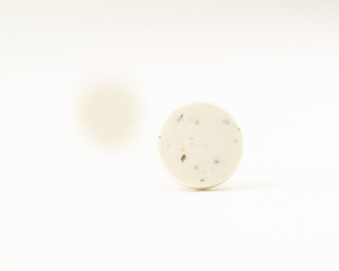 off-white stud earrings with speckles, bokeh view