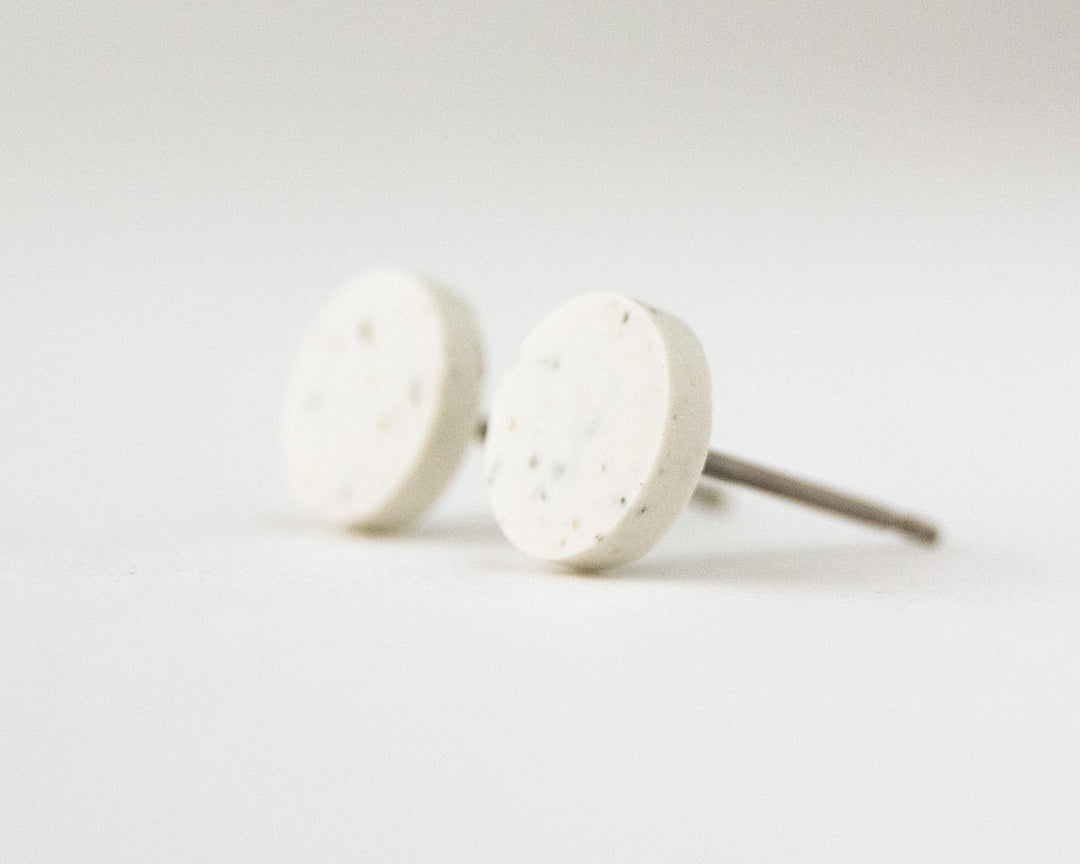 off white stud earrings with speckles, 45 degree view